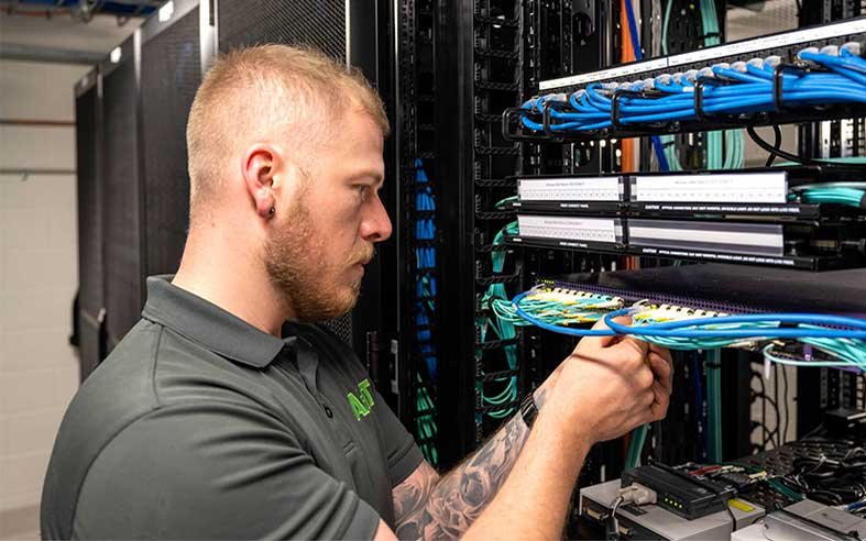 AV-asentaja kytkee kaapeleita laiteräkissä