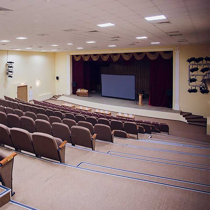 Auditorio, jossa riveittäin istuimia ja edessä esityslava