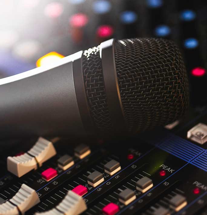 Mikrofoni mikseripöydällä äänentoistolaitteiden vieressä