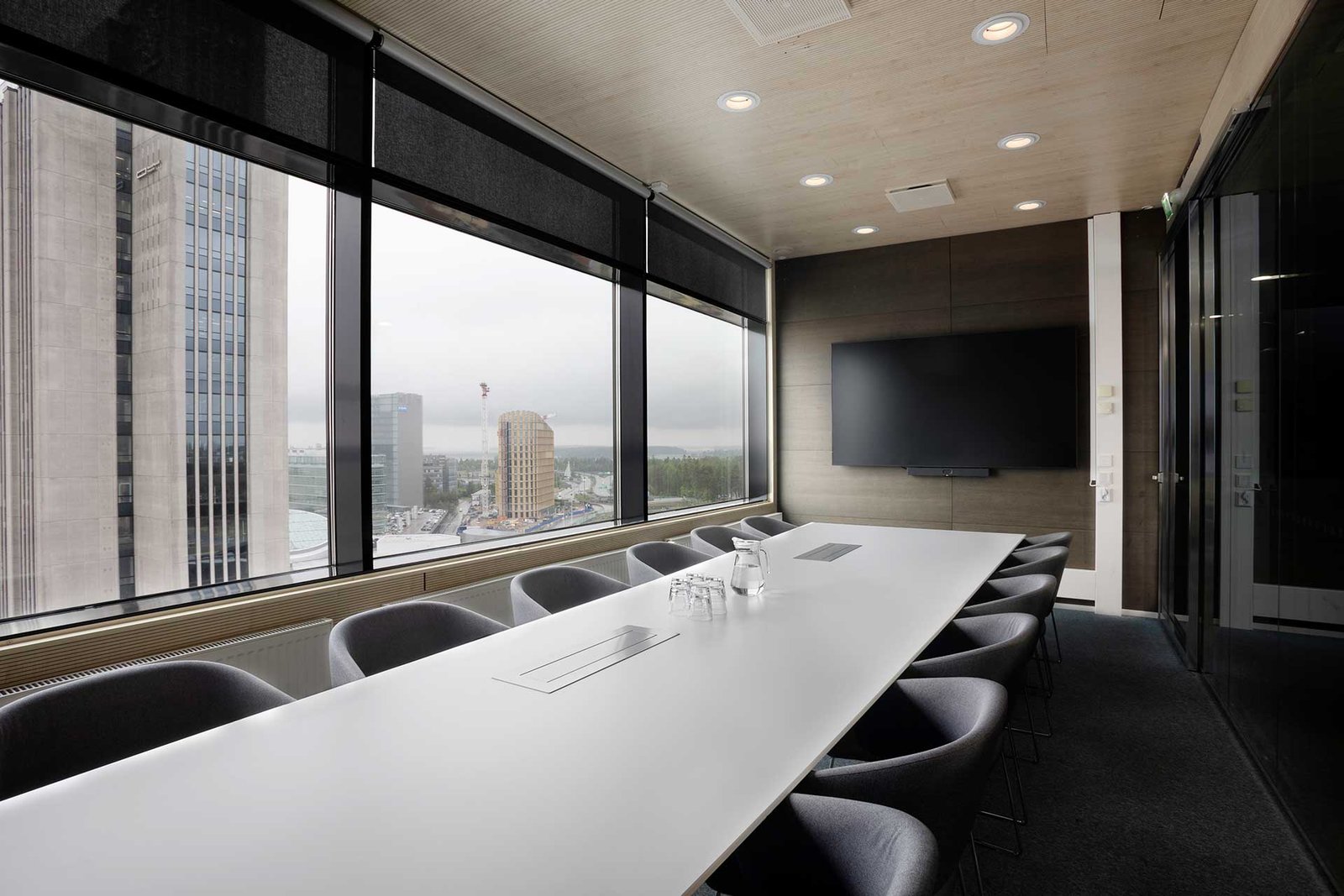 Valoisa neuvottelutila, jossa iso näyttö ja videoneuvottelulaitteisto